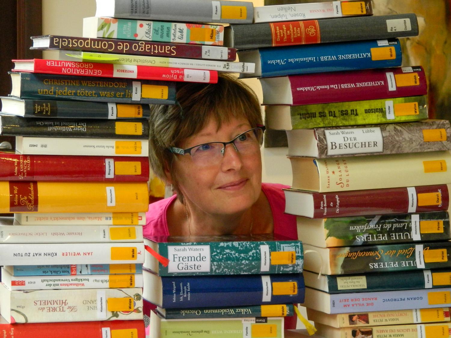 Frau zwischen Büchern (c) Bild: Borromäusverein In: Pfarrbriefservice.de